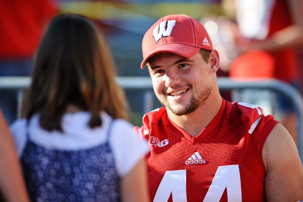 Badger inside linebacker Chris Borland (44) talks with a young fan during the Family Fun Day event at Camp Randall Stadium at the University of Wisconsin-Madison on Aug. 17, 2013. (Photo by Bryce Richter / UW-Madison)