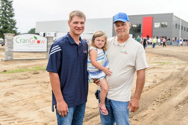 Adam Nemitz (left) is pictured with his father and daughter near the new CranGrow processing facility in Tomah, Wisconsin on Aug. 11, 2016. (Photo by Bryce Richter / UW-Madison)