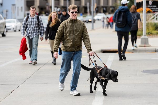 Drew Hasley and his guide dog, Shade, walk along West Johnson Street